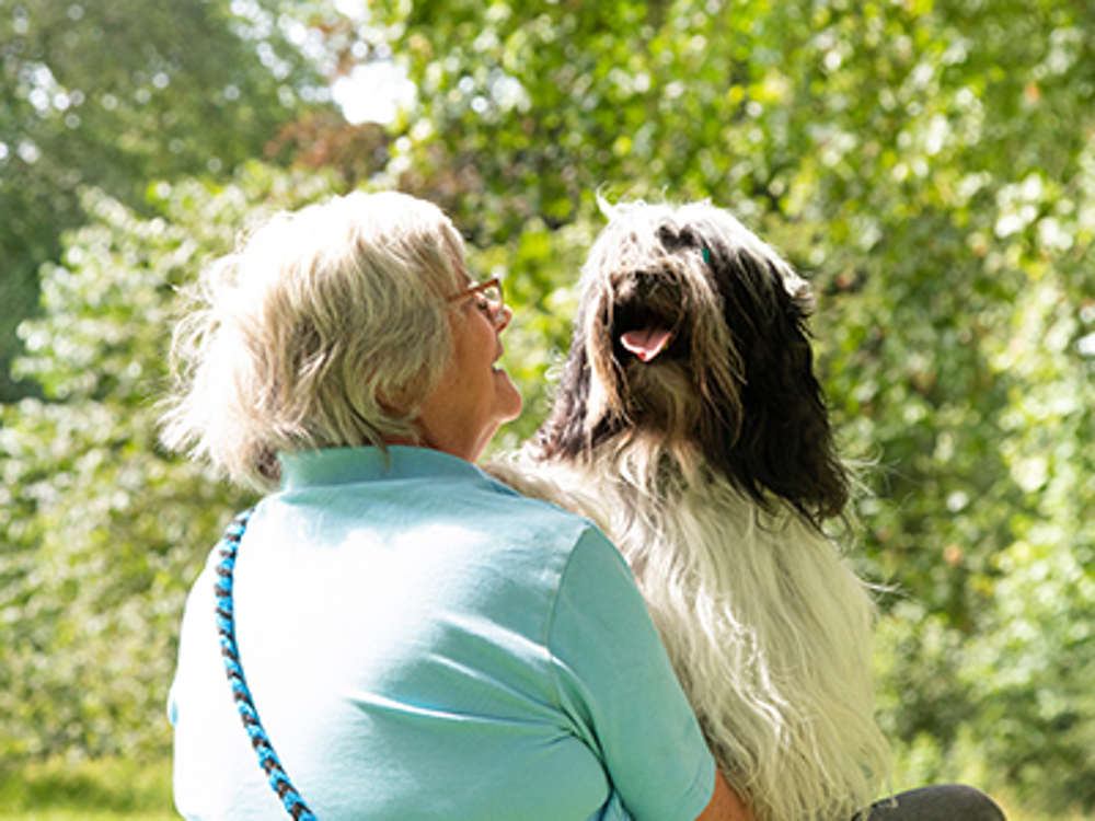 A woman embracing her happy dog